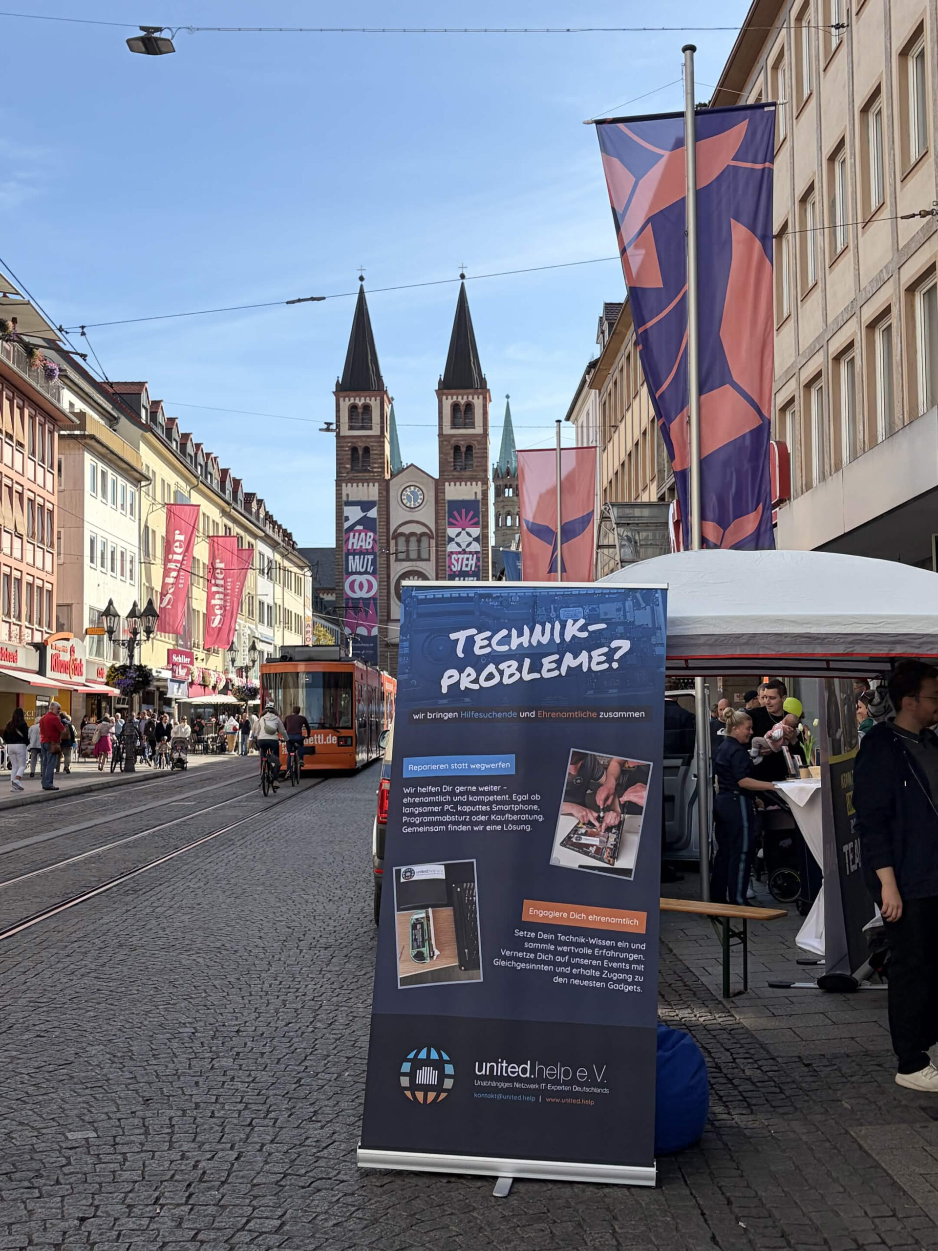 Infostand von united.help e.V. mit Rollup und Blick auf den Würzburger Dom